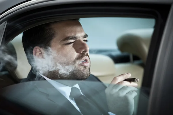 Man in the back seat of a car smoking