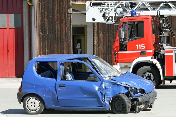 Car destroyed in a traffic accident and trucks of firefighter