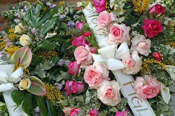 Bouquets of flowers with roses and mimosas in memory of dead