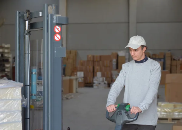 Young man using forklift in a warehouse