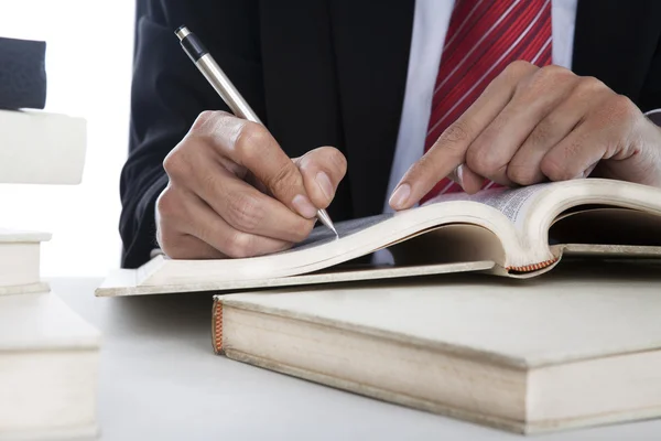 Closeup of businessman writing on a book