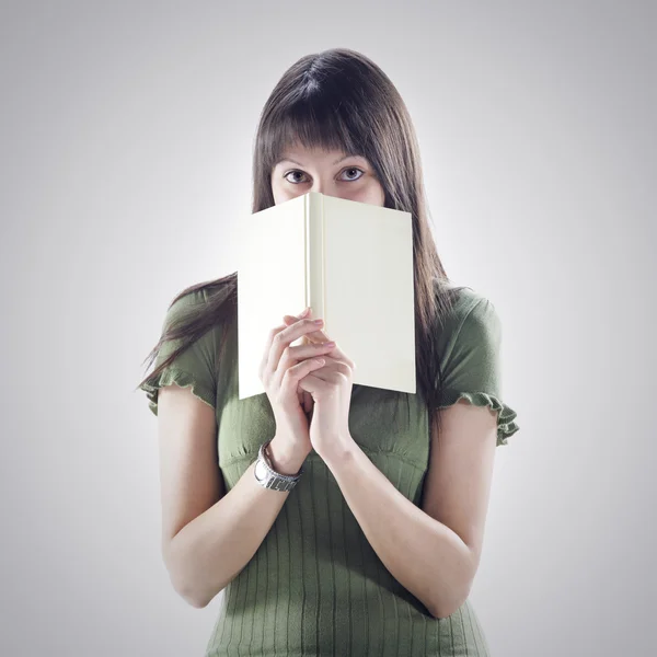 Woman hides behind a book . cover is blank