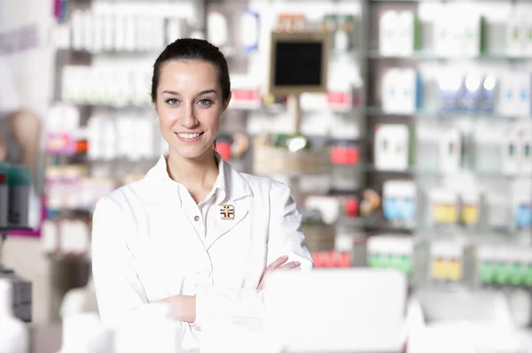 Portrait of young healthcare worker and background pharmacy.