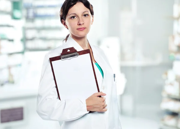 Female doctor holding blank clipboard. You can add your message