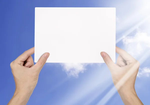 Businessman hand holding blank paper on blue sky background