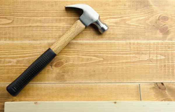 Hammer and nails are on a wooden planks