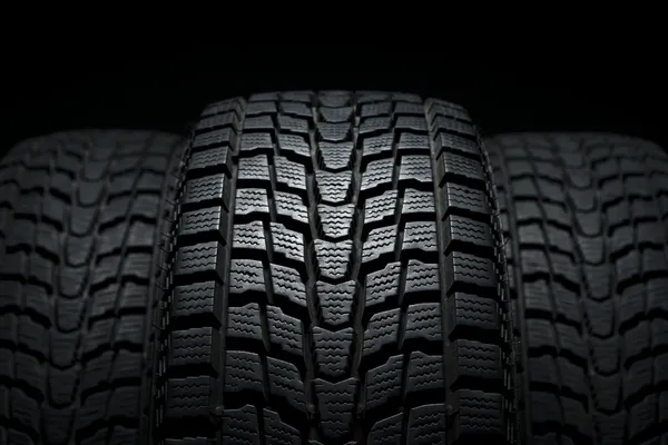Three black winter tires in studio shot