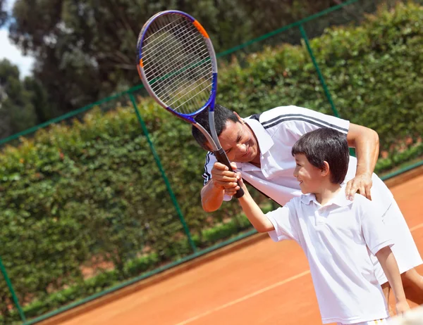 Father and son playing tennis