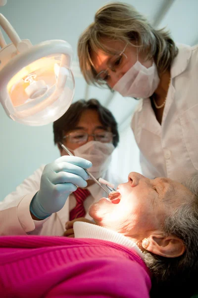 Dentist working on and old patient