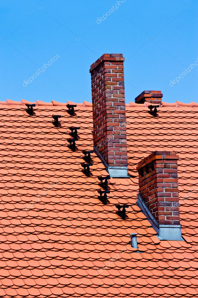 Chimenea de techo y ladrillos tejas rojas en cielo azul — Foto de stock