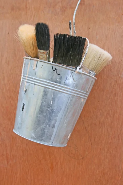 Paint brushes in a bucket.