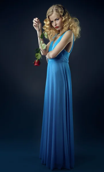 Beautiful girl in dark blue dress with rose