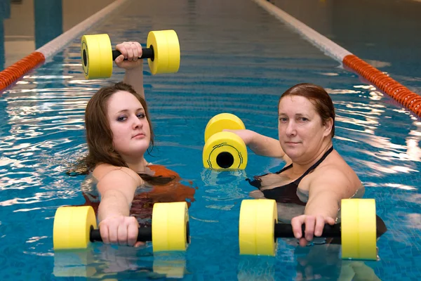 Two womam in water with dumbbells