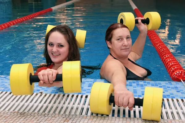 Two womam in water with dumbbells