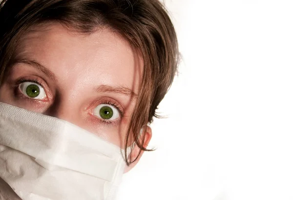 Woman with big green eyes wearing medical mask protecting against flu virus