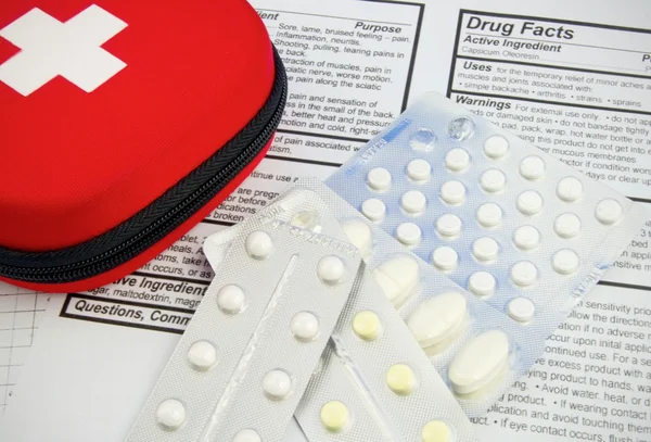 Medicines, pills and first aid kit on drug facts document