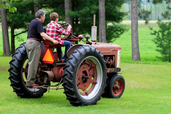 Grandfather and Grandson Driving a Vintage Tractor