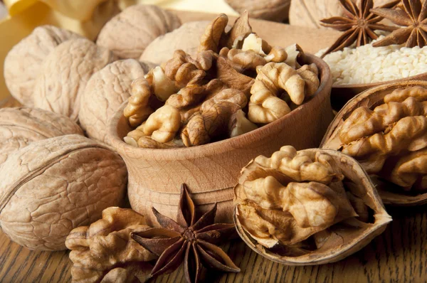 Wood nut, walnut, anise, cinnamon and sesame against a dark background