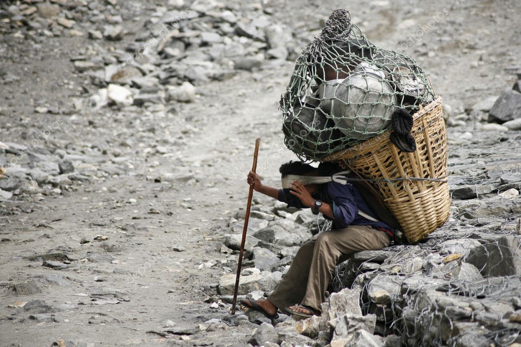 Man carrying heavy load, annapurna, nepal Stock Editorial Photo