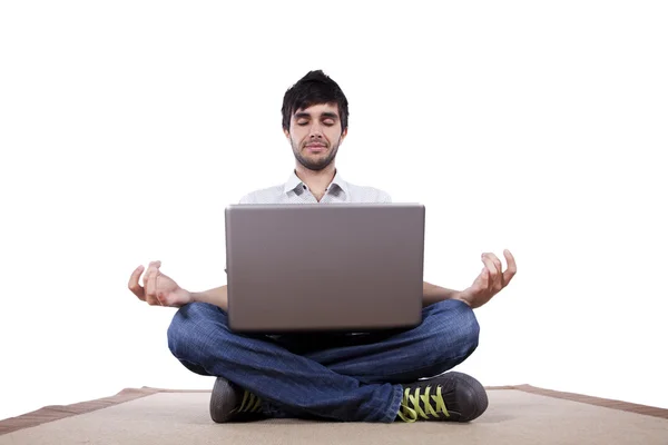 Young man meditating with his laptop
