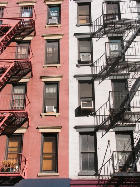 Red and white wall with windows and fire escape