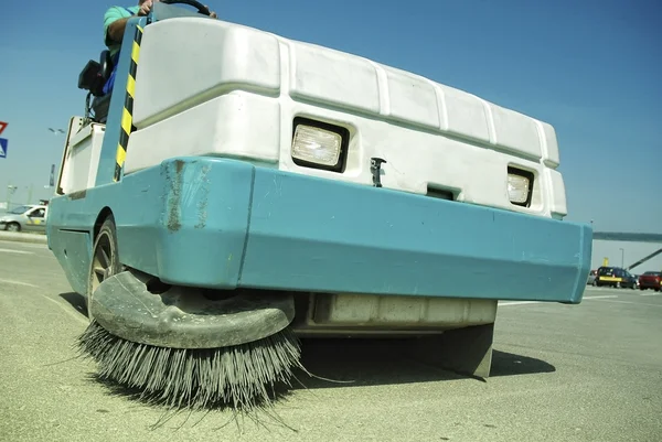 A sweeping machine cleans the parking space