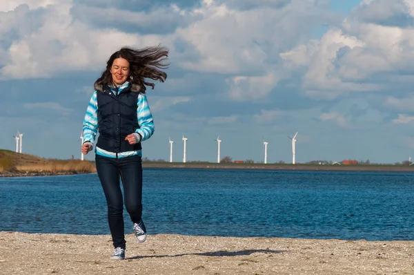 Happy active woman runs on beach