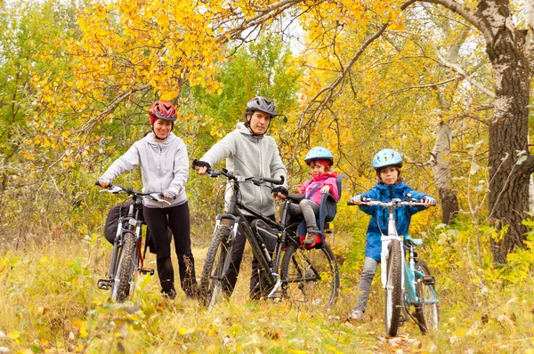 Happy active family cycling on bikes outdoors