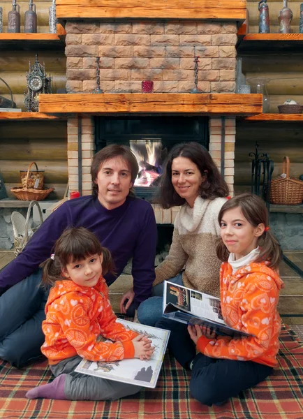 Happy family having fun near fireplace in wooden house