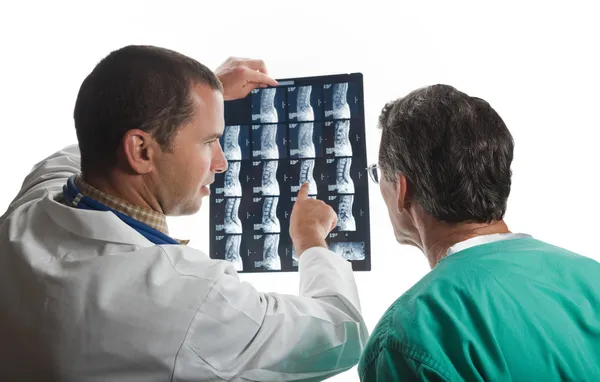 Two Doctors Examining Patient\'s Spinal Film Scans