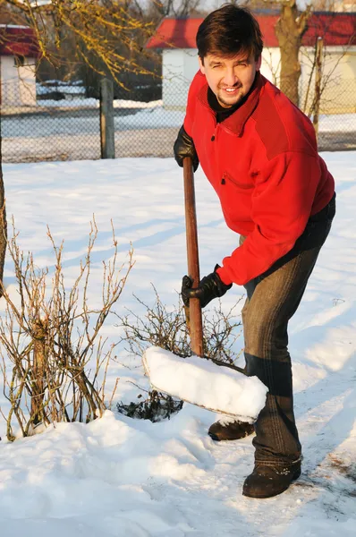 Adult man clean owns yard against snow