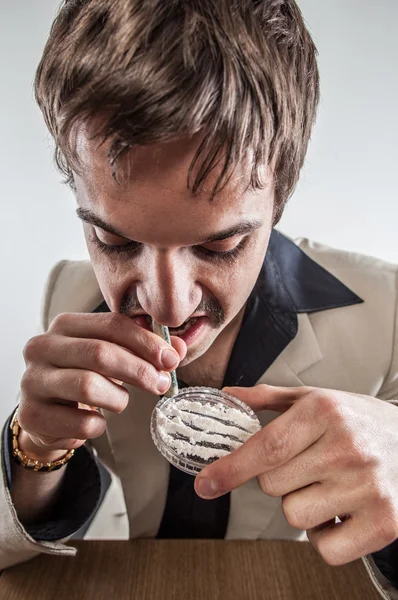 Vintage business man with gold watch snorting cocaine on table.