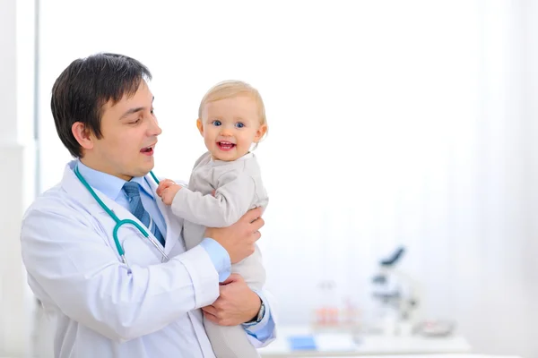 Portrait of happy cute baby on hands of pediatrician