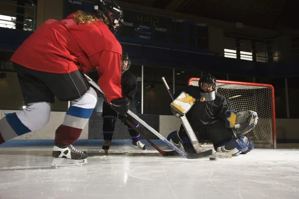 Women playing hockey.