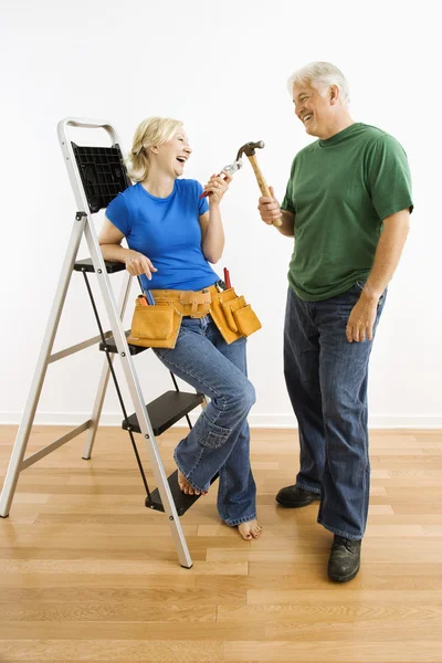 Man and woman with tools and ladder.