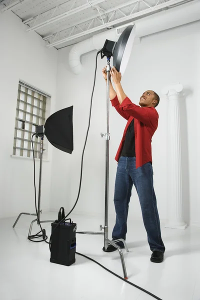 Man adjusting studio lights.