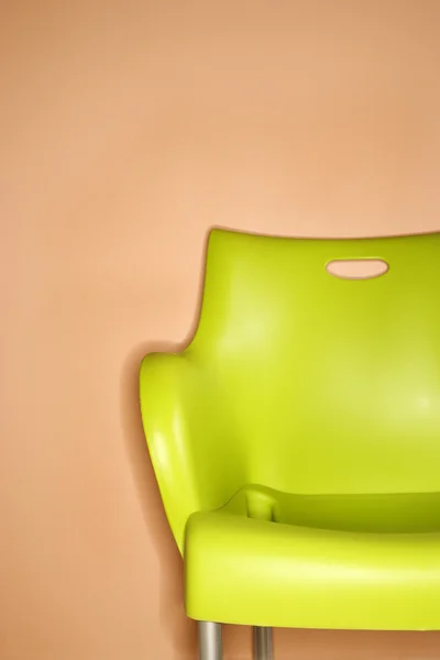 Green chair against wall.