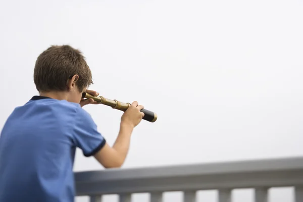 Boy looking through telescope.