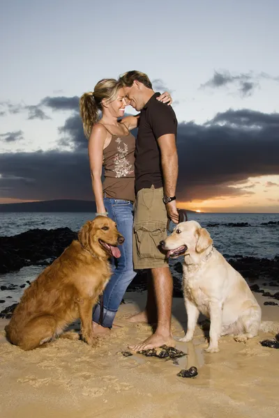 Affectionate Couple With Dogs at the Beach