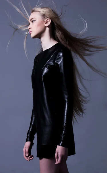 Woman in leather dress with long blowing hair