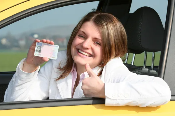 Young woman showing her driver license