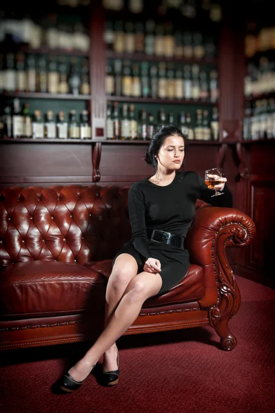 Young woman with a glass of brandy