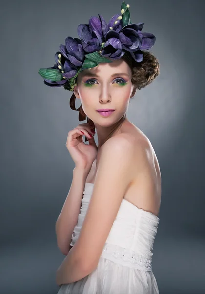 Sensual fashion model pretty girl in wreath of flowers looking at camera