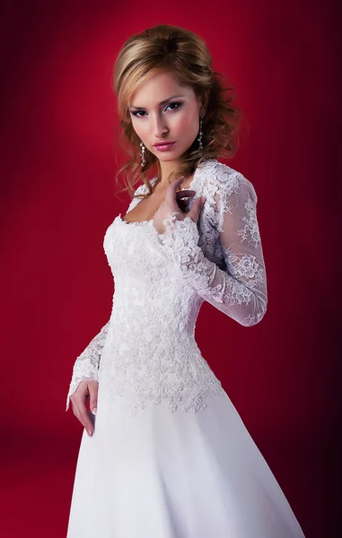 Stylish pretty woman in bridal white dress posing in studio