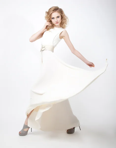 Beautiful woman blonde in flying vernal white dress
