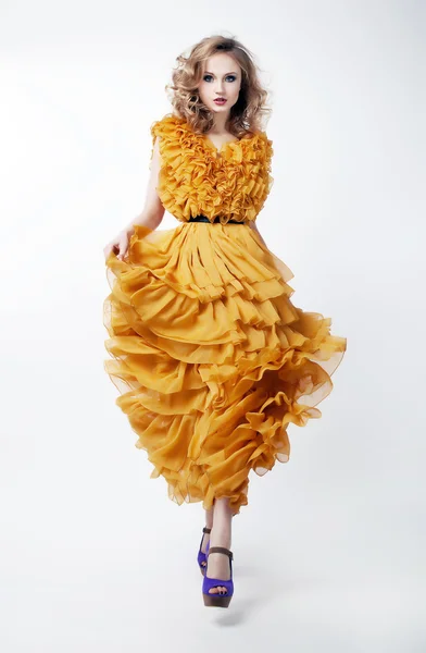 Lovely woman blonde fashion model in yellow dress posing