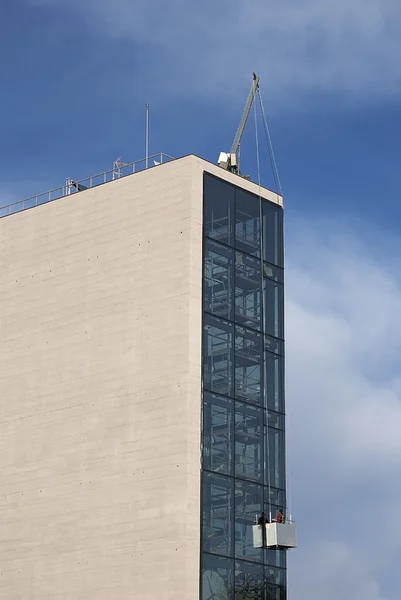 A Window washer work high above the city streets