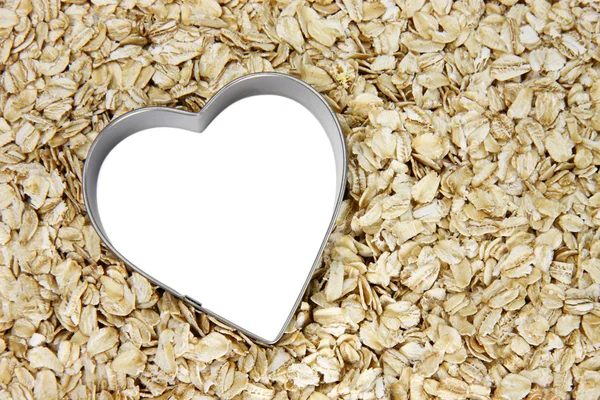 White heart outlined with silver on a bed of oatmeal