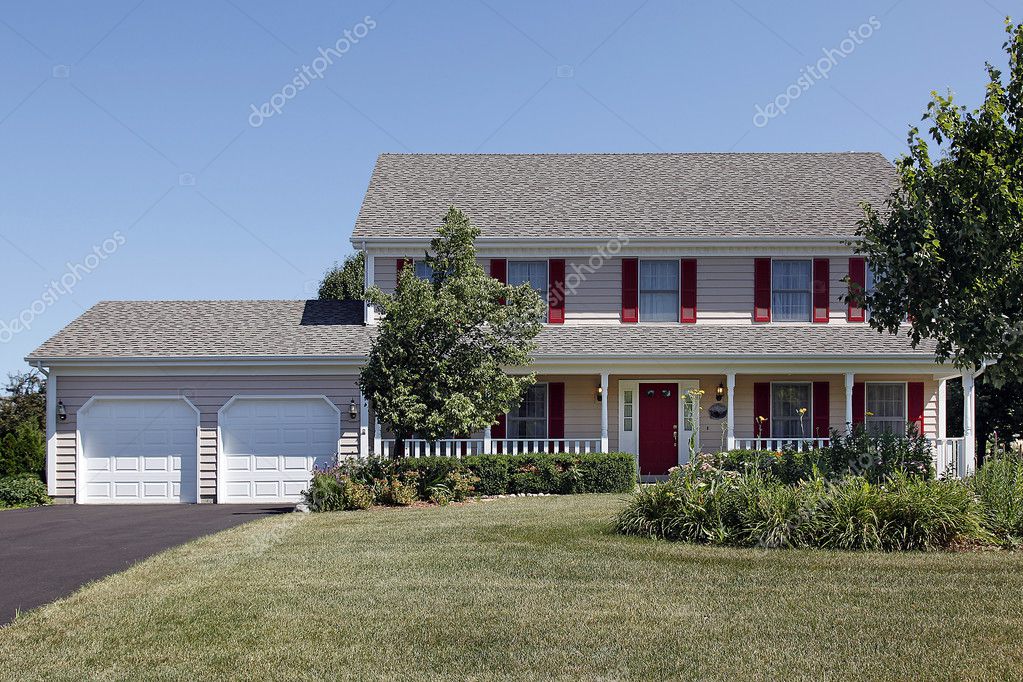 Zweigeschossiges Haus mit Veranda und roten Fensterläden ...