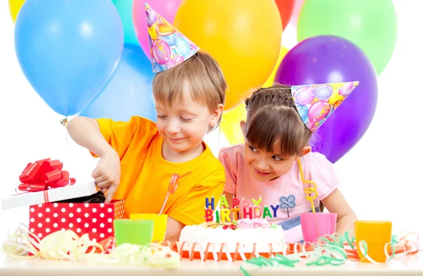 Adorable children celebrating birthday party and opening gift bo